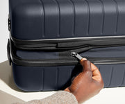 The Bigger Carry-On Flex suitcase in Navy Blue has an additional wraparound zipper to expand the suitcase 2.25" (6 cm) and increase packing space