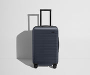 Front product view of The Carry-On Flex suitcase in Navy Blue with raised handle