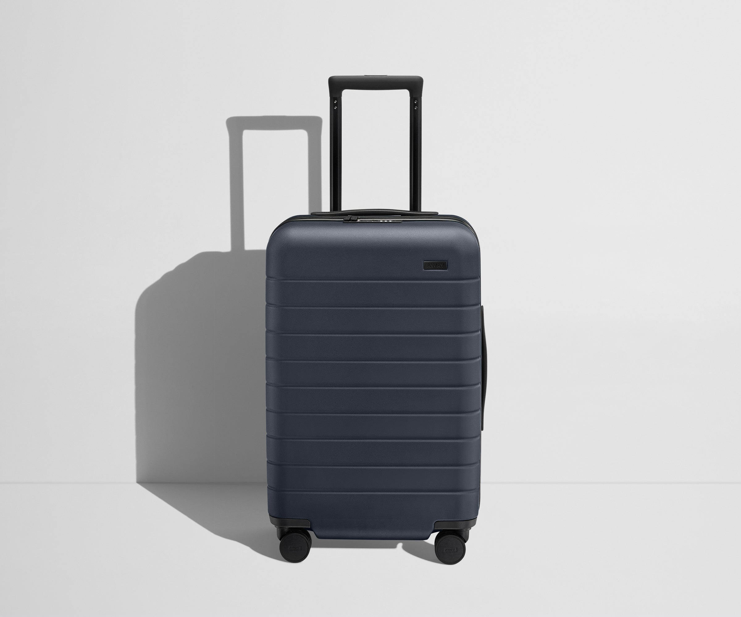 Front product view of The Carry-On Flex suitcase in Navy Blue with raised handle