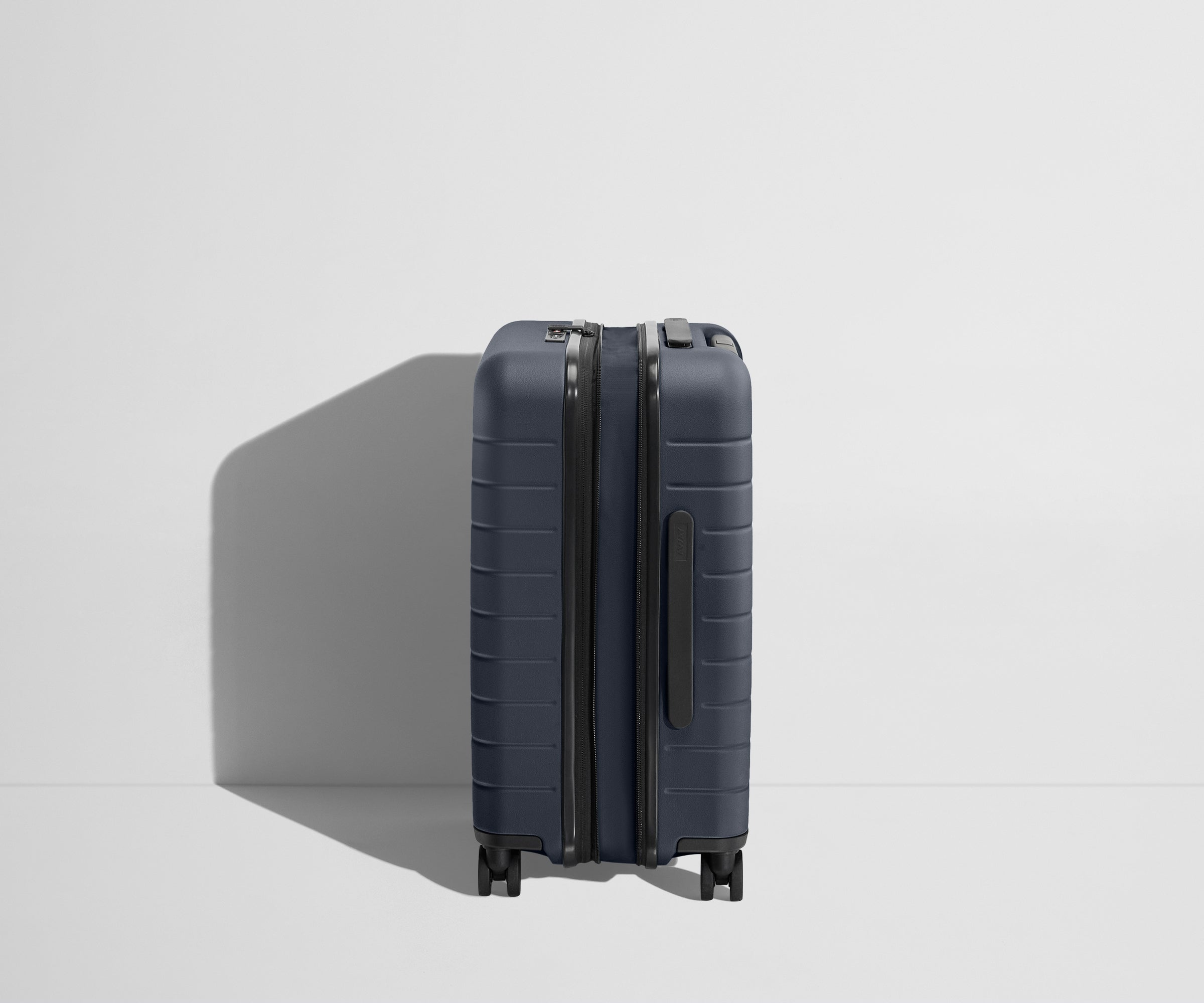 Side product view of The Carry-On Flex suitcase in Navy Blue shown fully expanded