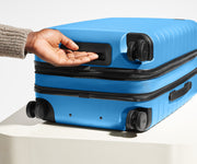 The Bigger Carry-On Flex suitcase in Splash Blue shown from below highlighting the underside grab handle