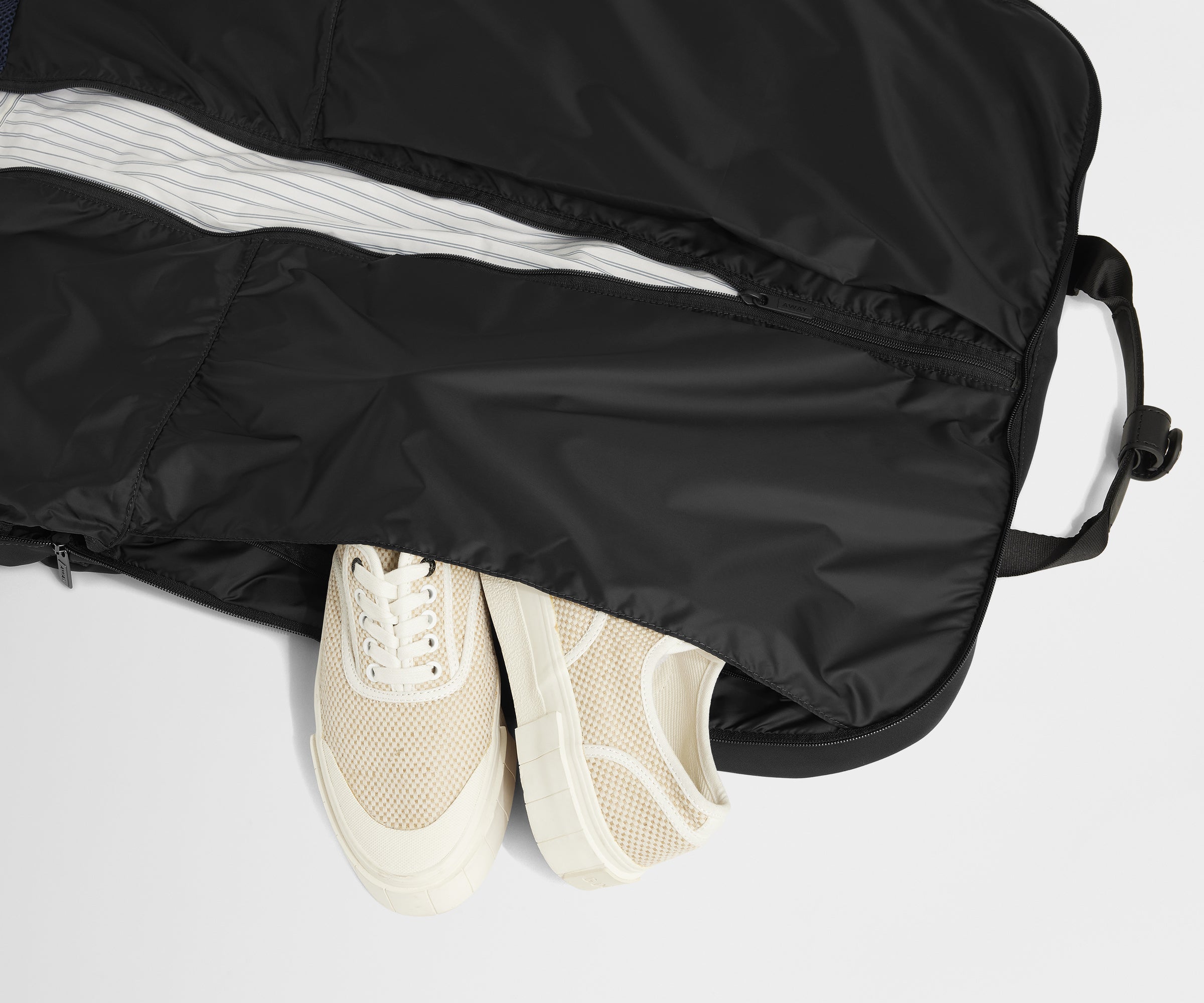 Showing one of two dedicated shoe pockets of the Garment Bag in Jet Black