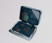 Open blue suitcase with organized compartments on a light gray background