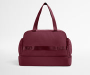 Maroon duffel bag on a light gray background