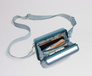 Blue crossbody bag with a strap on a light gray background
