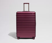 Maroon suitcase on a light gray background