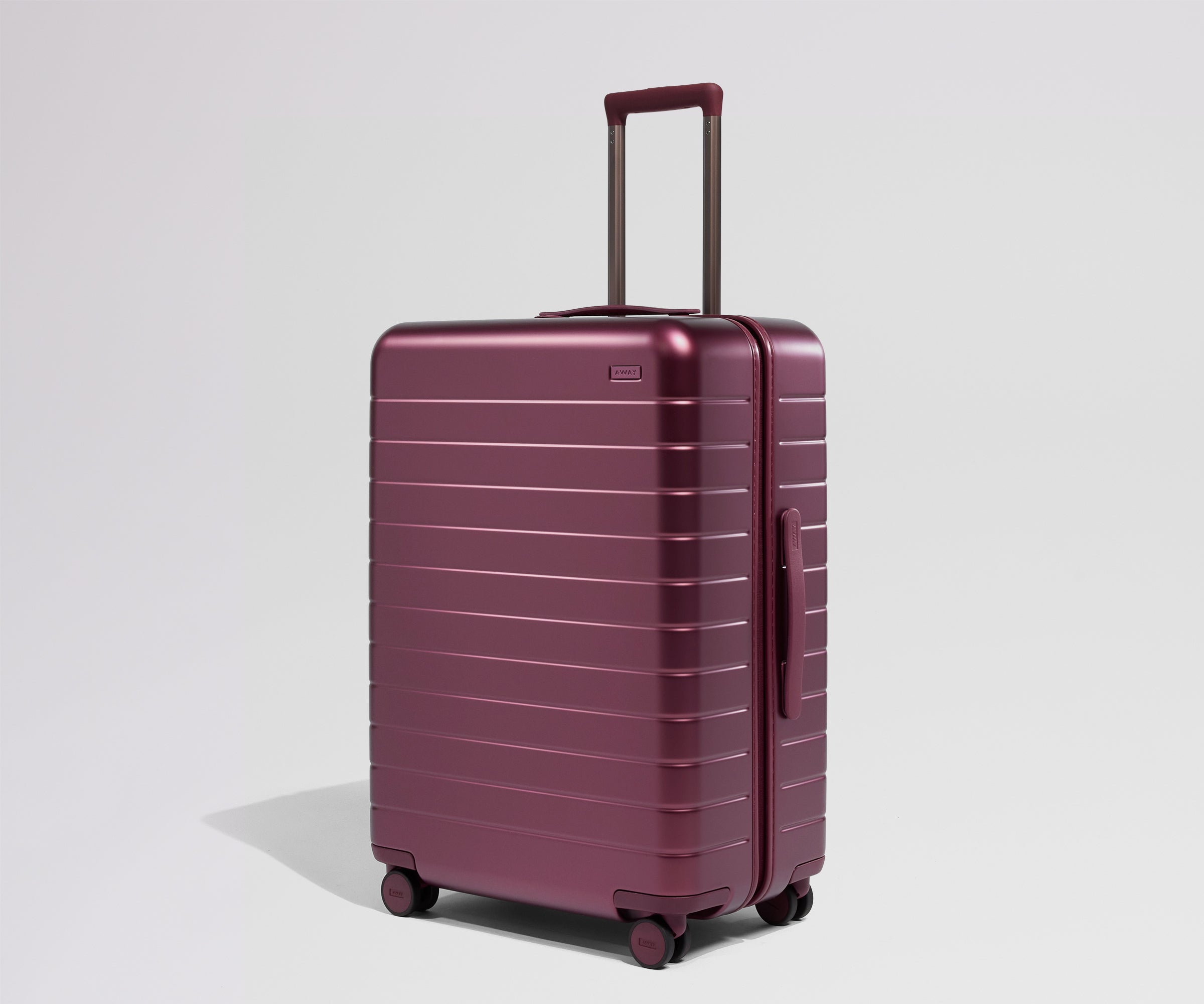 Maroon suitcase with a handle on a light gray background