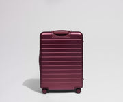 Back view of a maroon suitcase on a light gray background