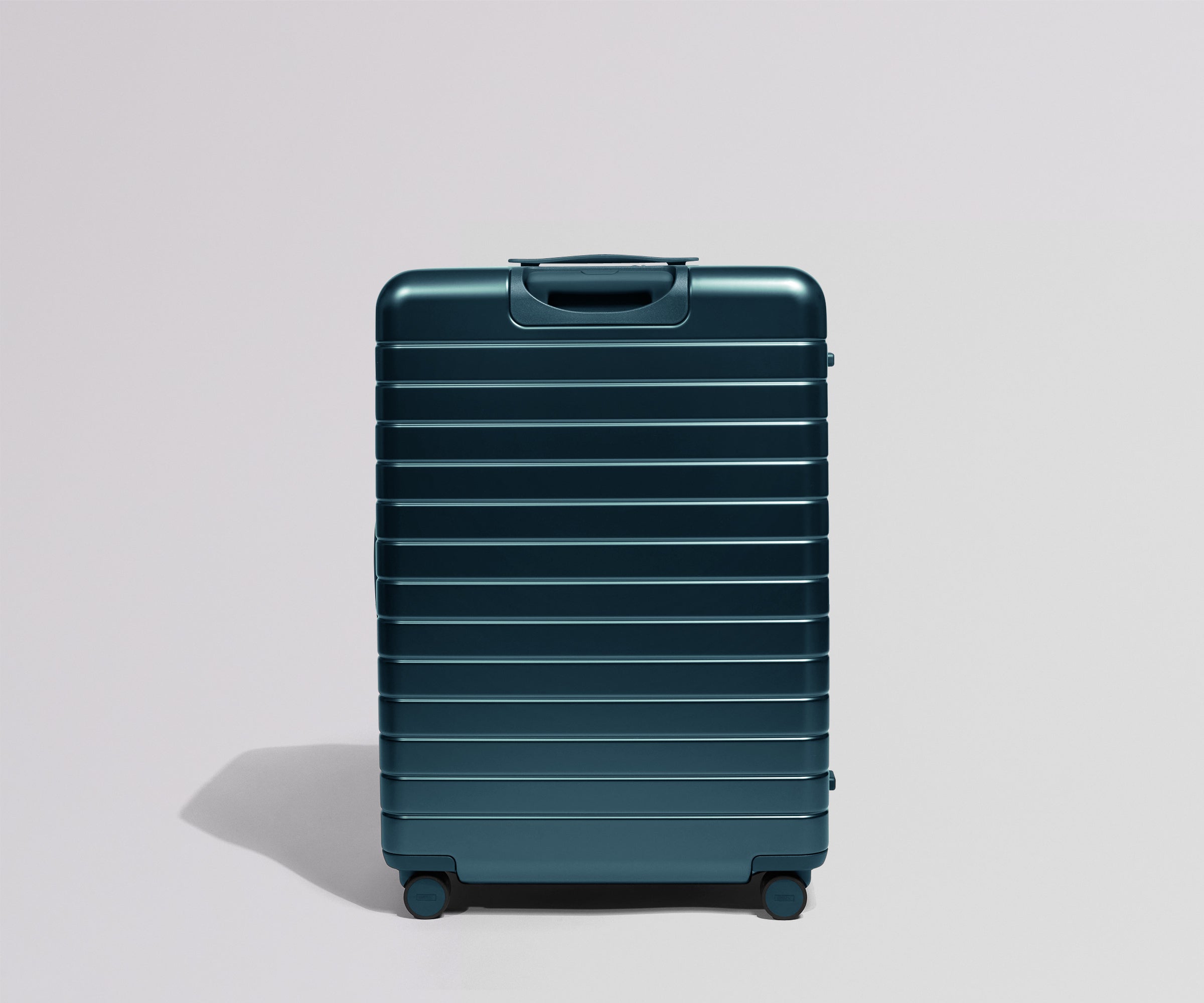 Back view of a teal suitcase on a light gray background
