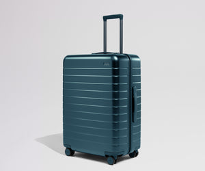 Teal suitcase with a handle on a light gray background