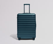 Teal suitcase on a light gray background