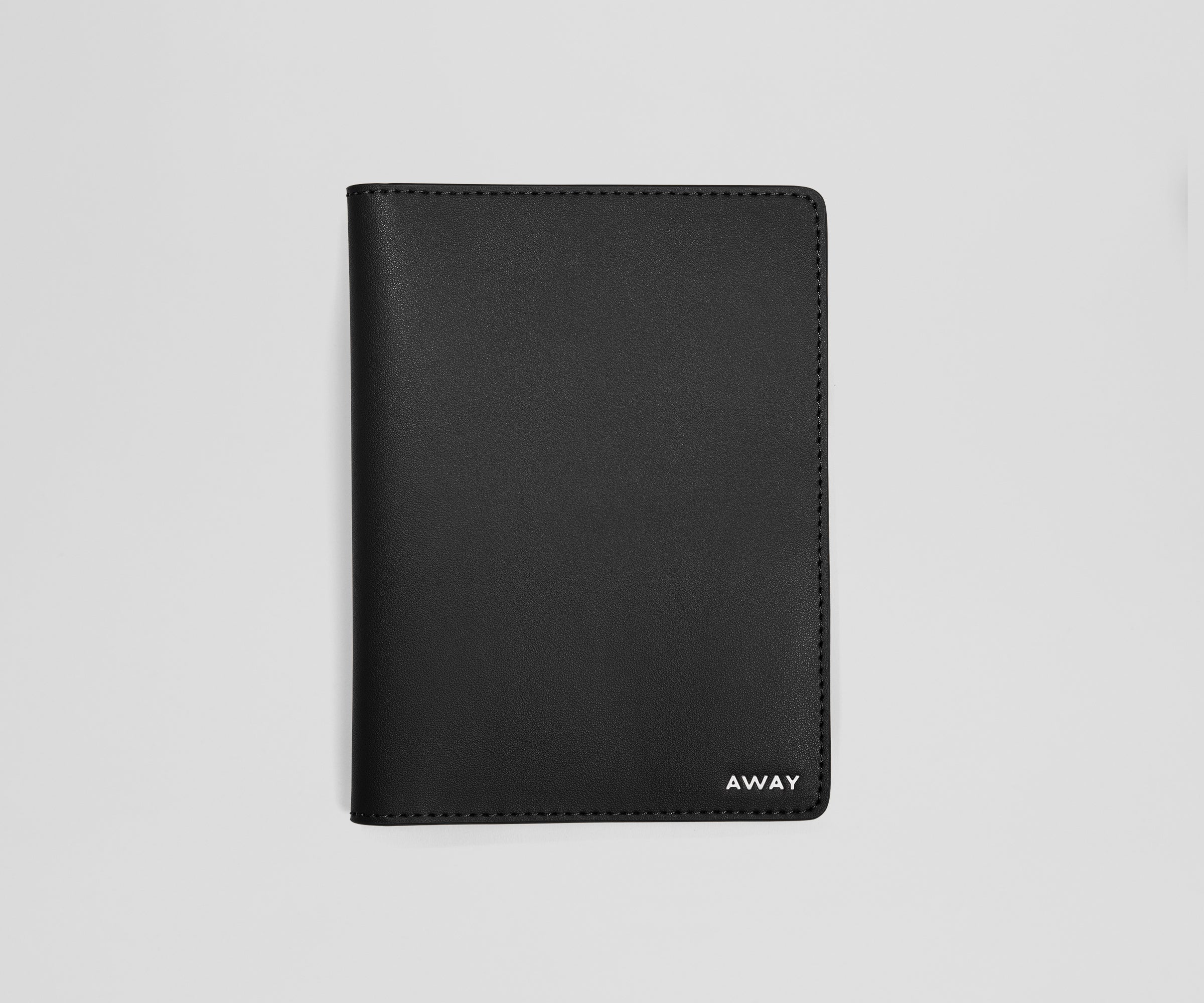 Black leather passport holder with 'AWAY' branding on a light gray background