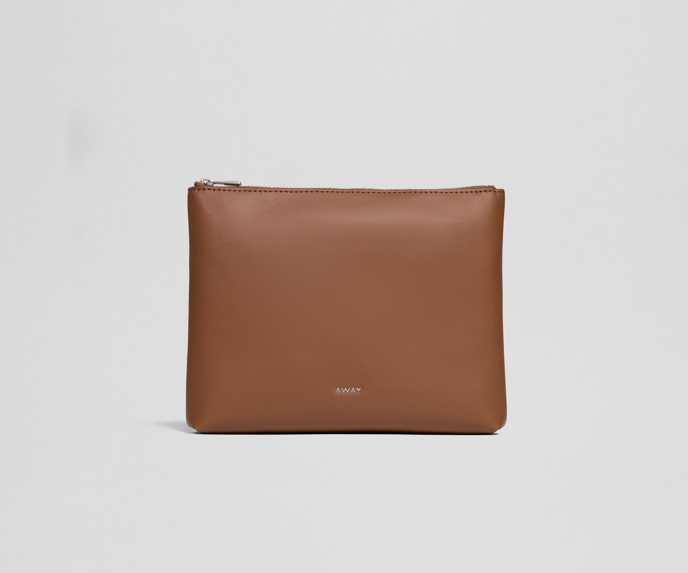 Brown leather pouch with 'AWAY' branding on a light gray background