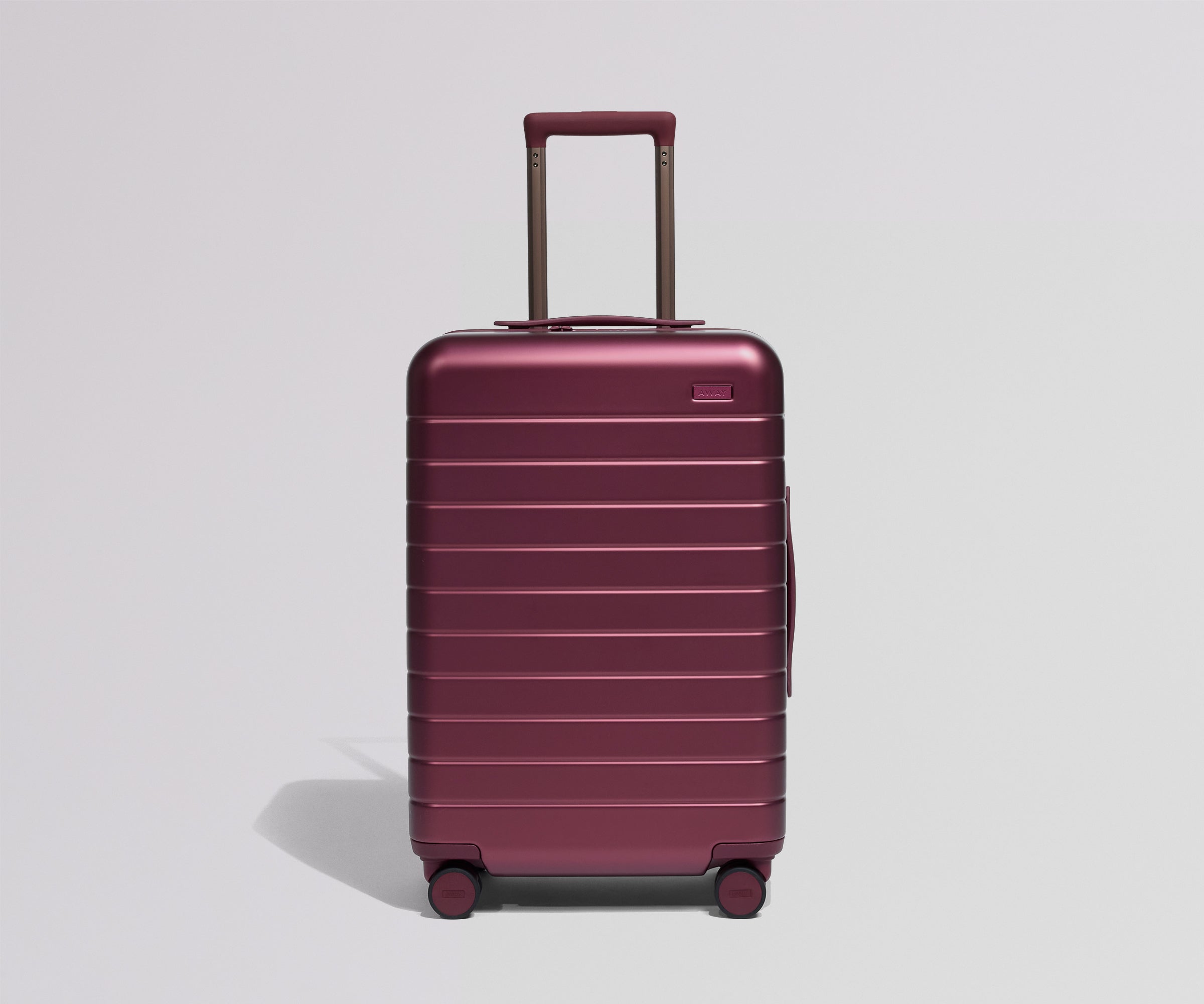 Maroon suitcase with a handle on a light gray background