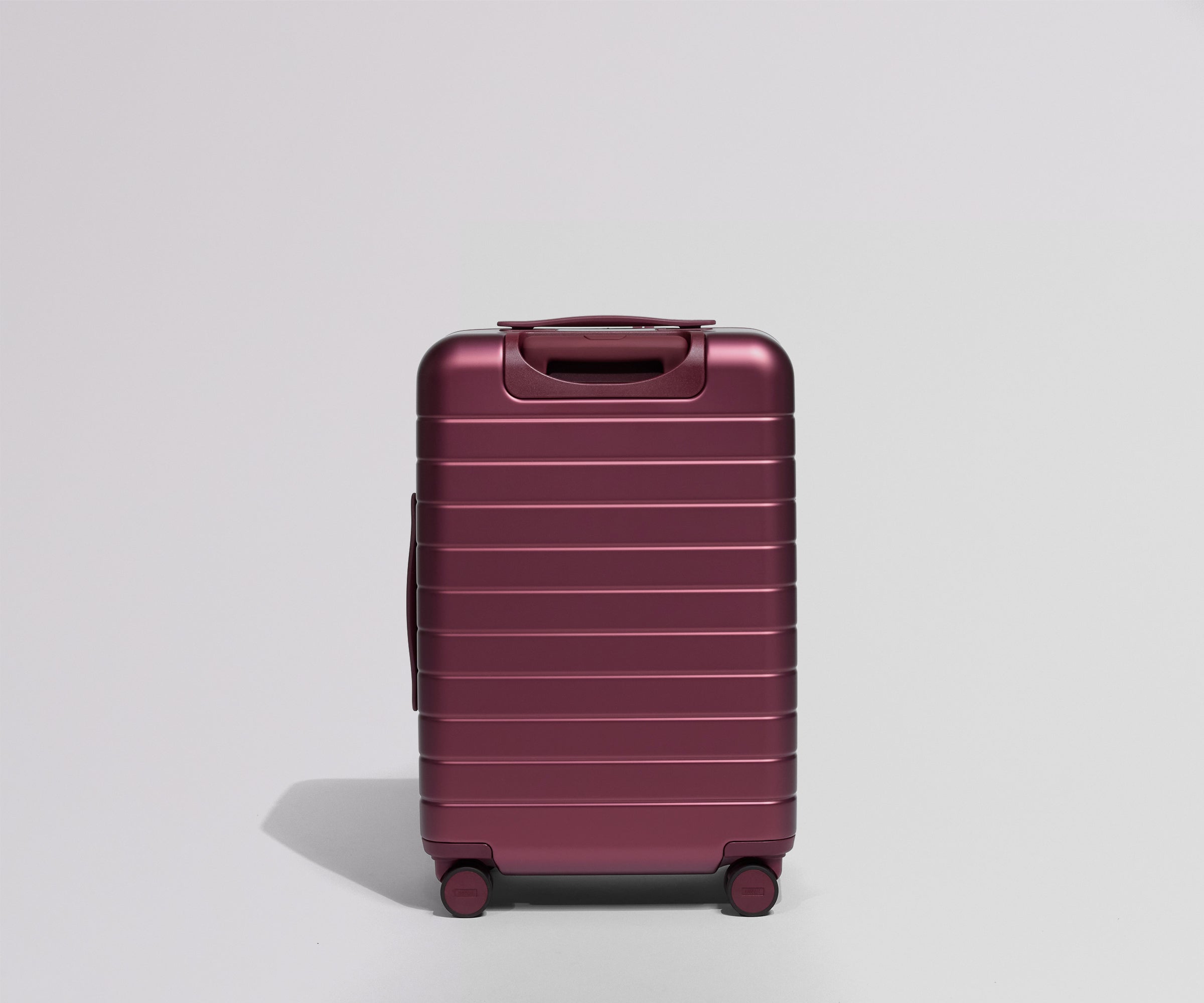 Maroon suitcase back view on a light gray background