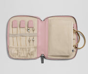 Pink jewelry case with compartments for earrings and a ring on a light gray background