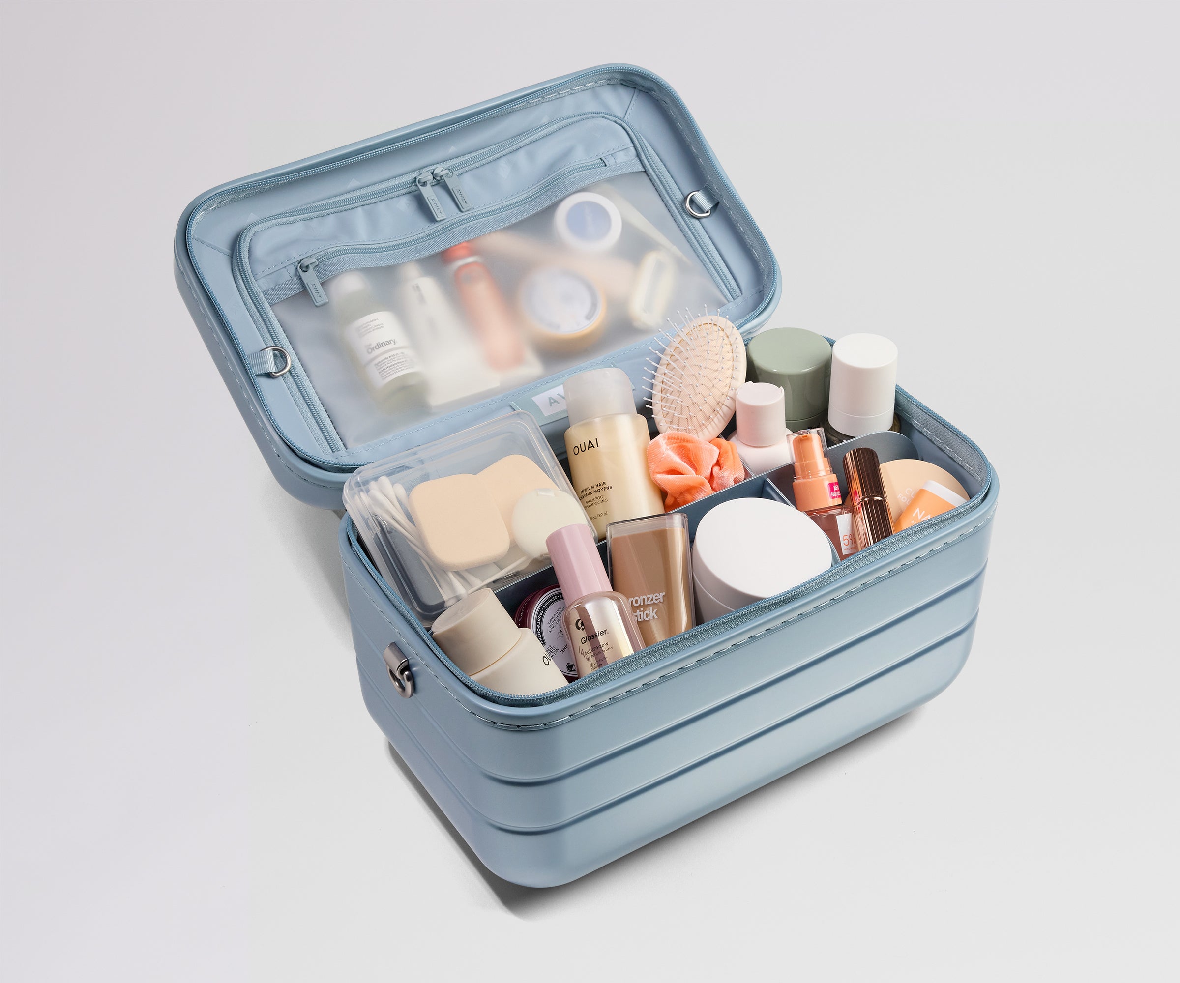 Blue makeup case with various cosmetic products on a light gray background