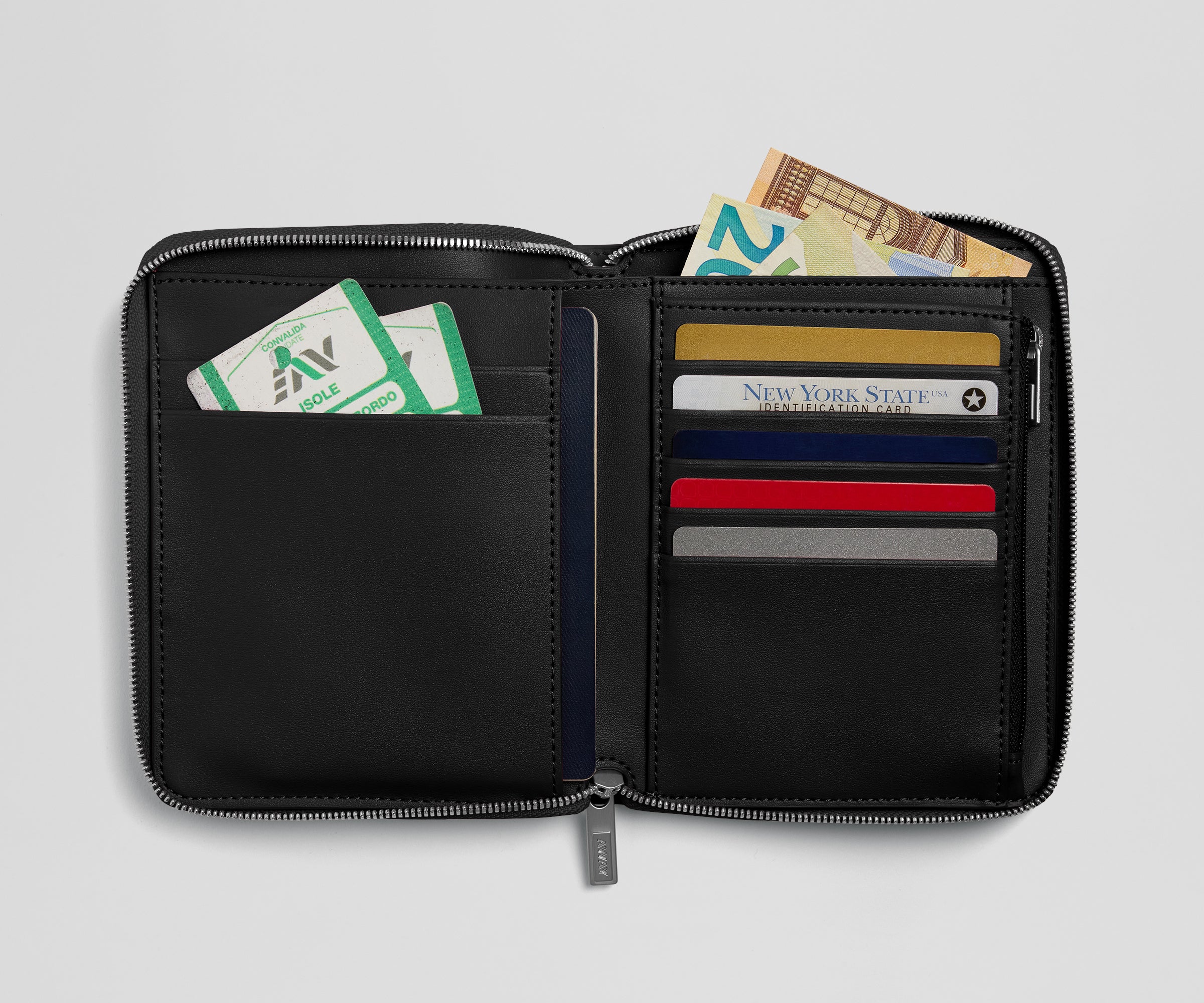 Black zippered wallet with various cards and money on a light gray background