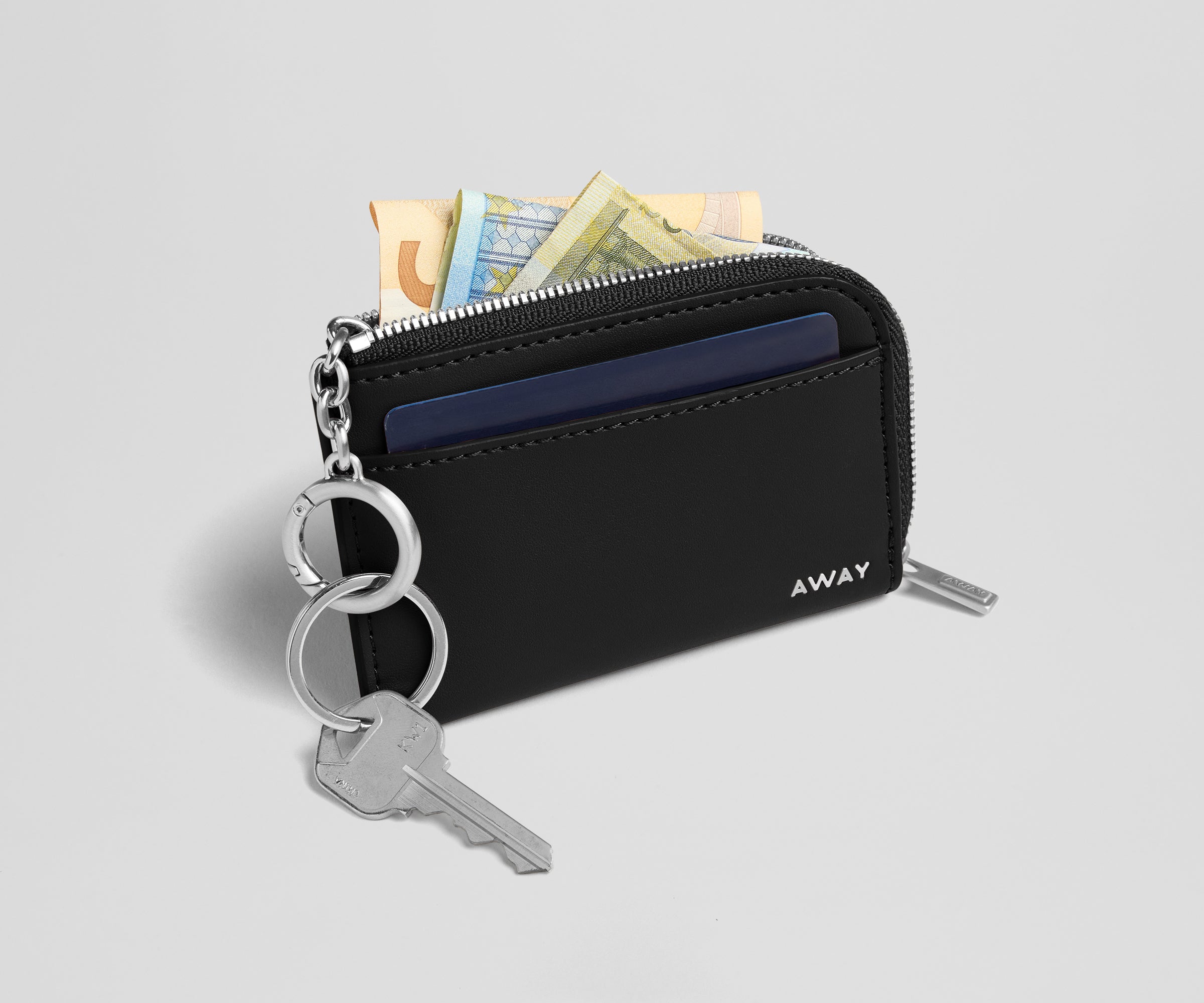 Black wallet with keys and money on a light gray background