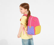 A child model wearing the Kids Backpack in Cotton Candy Pink with the chest strap in use