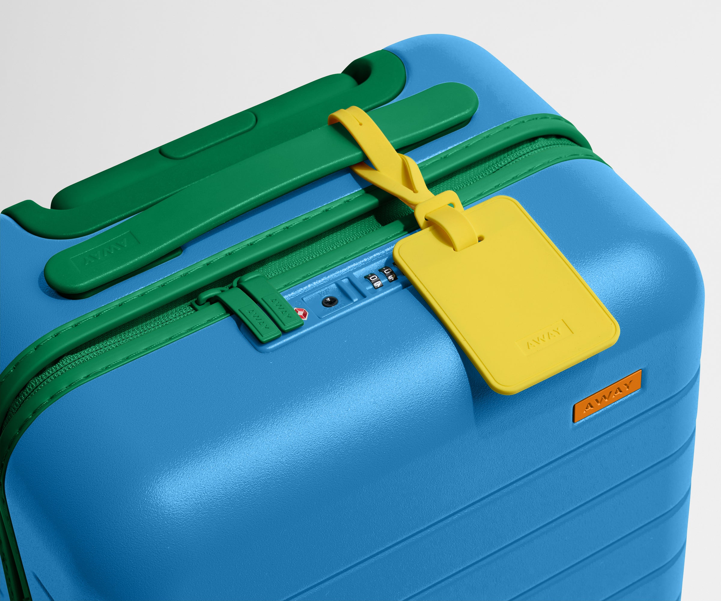 The Kids Carry-On suitcase in Splash Blue shown shown from above highlighting TSA-approved combination lock and colorful silicone luggage tag