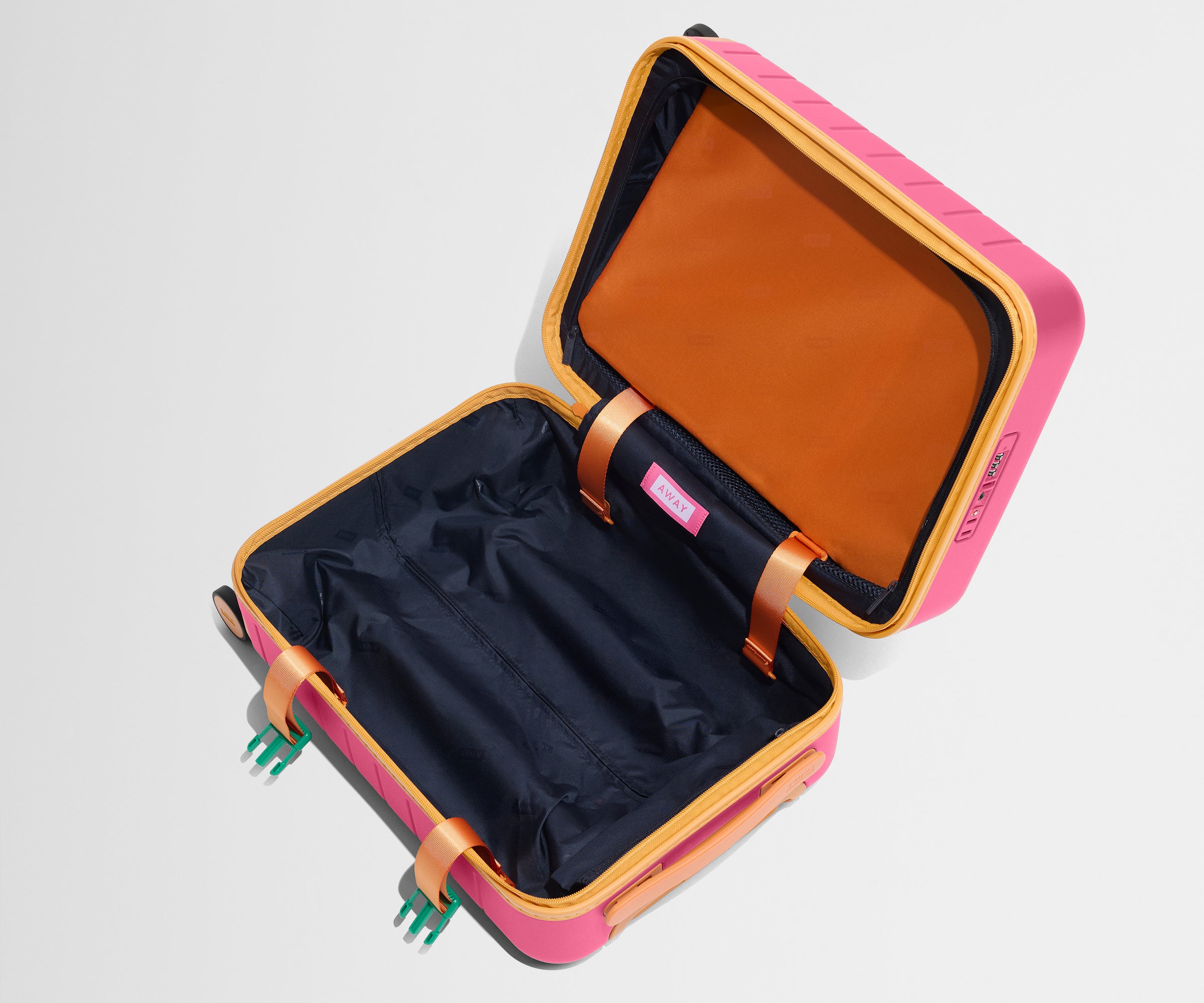The Kids Carry-On suitcase in Cotton Candy Pink shown open and empty on its side to show capacity
