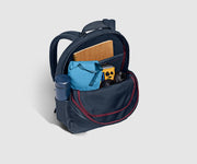 Main compartment packed with an organizational pouch, notebook, and headphones. Water bottle in the exterior water bottle pocket
