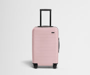 Pink suitcase with a black handle on a light gray background