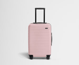 Pink suitcase with a black handle on a light gray background
