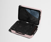 Pink suitcase with open compartment on a light gray background