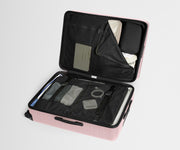 The Large suitcase in Blush Pink shown open on its side and packed with Away's packing organizers to show capacity and the interior compression system, designed to help you pack more in
