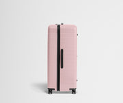Side product view of The Trunk suitcase in Blush Pink to show the slimmer top lid and deeper main compartment for easy access and packing