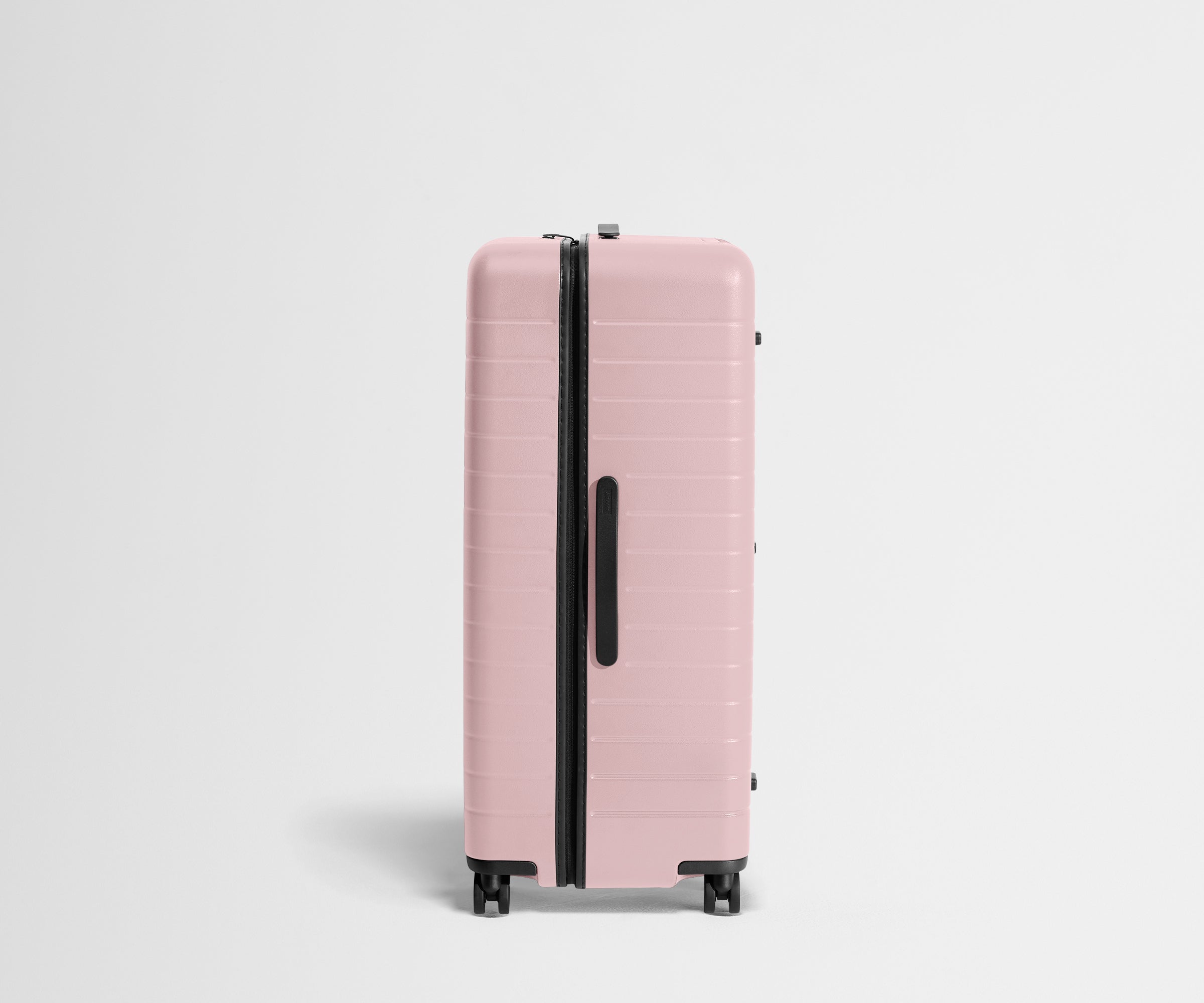 Side product view of The Trunk suitcase in Blush Pink to show the slimmer top lid and deeper main compartment for easy access and packing