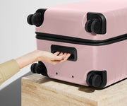 The Trunk suitcase in Blush Pink shown from below highlighting the underside grab handle