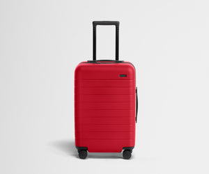 Red suitcase with a black handle on a light gray background