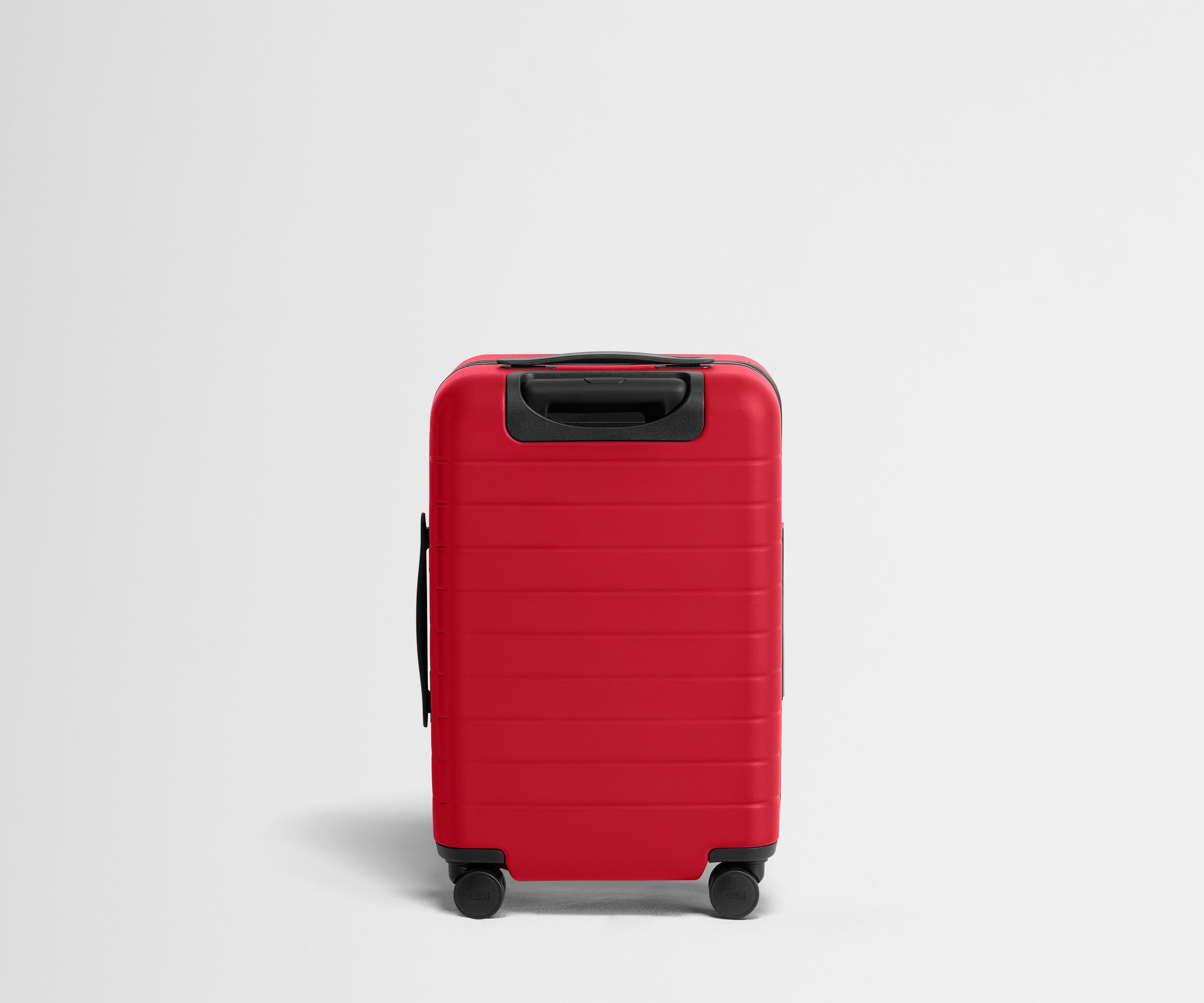 Red suitcase with black handle and wheels on a light gray background