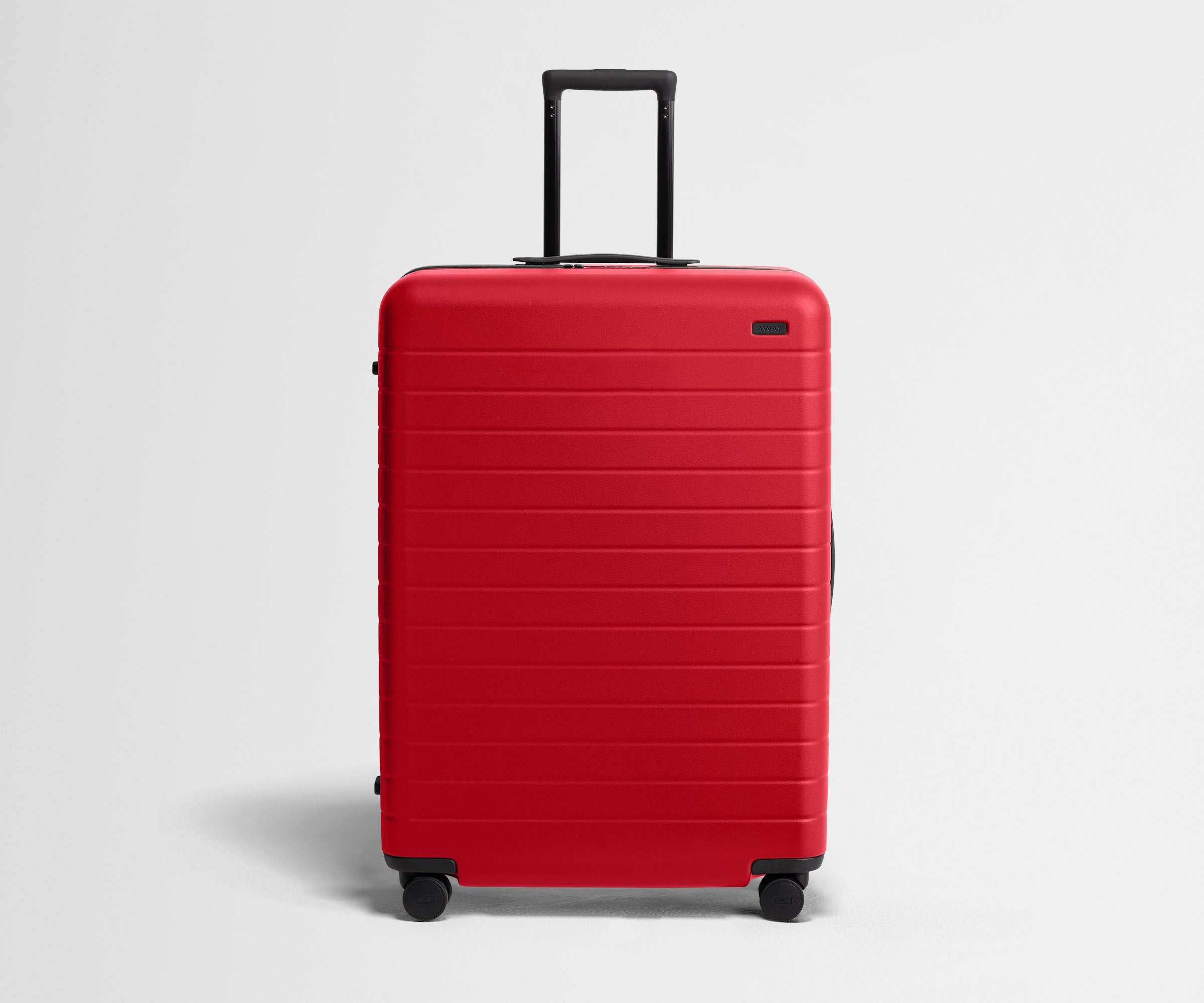 Red suitcase with black handle on a light gray background