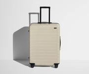 Front product view of The Medium suitcase in Salt White (Gloss) with raised handle