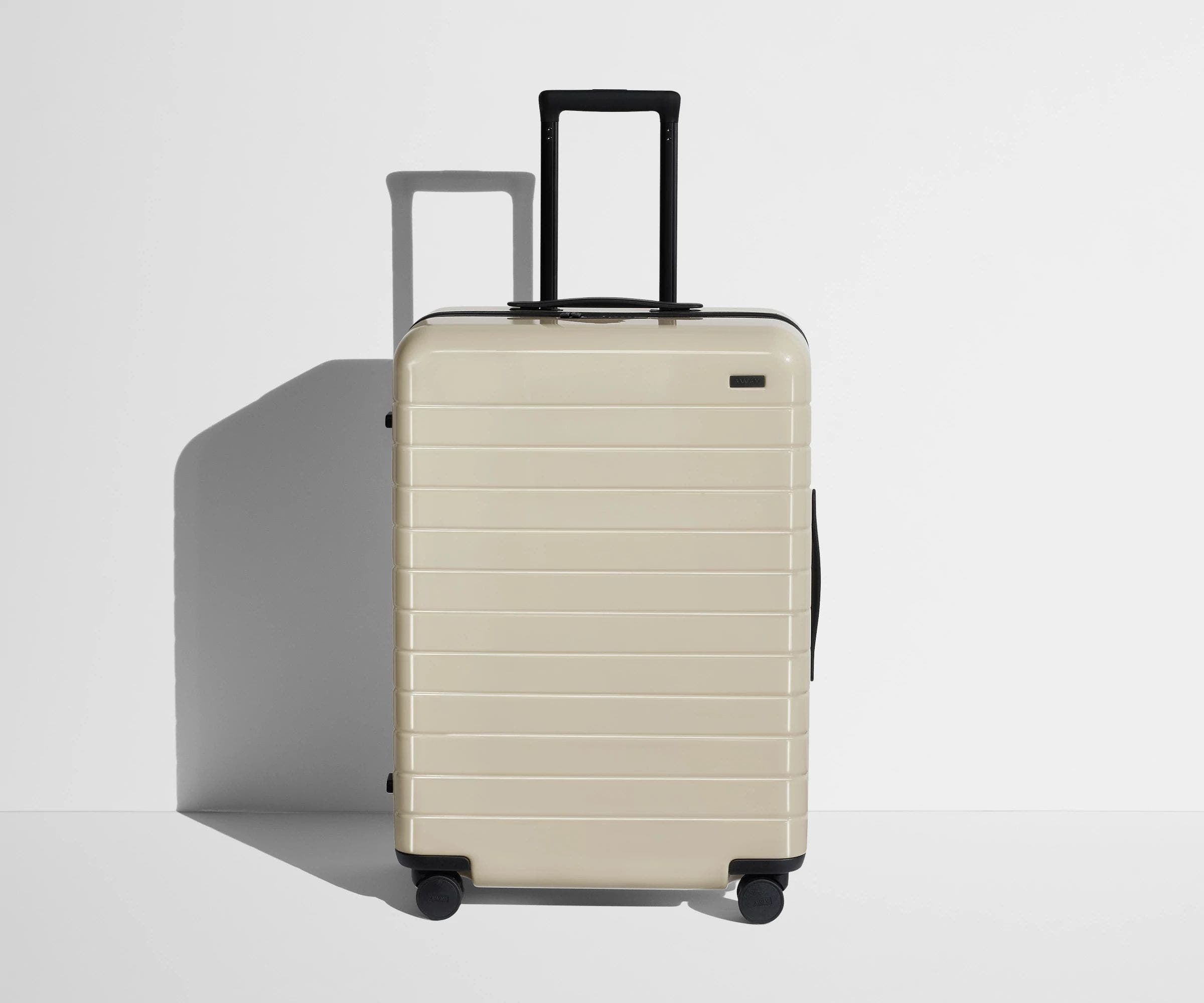 Front product view of The Medium suitcase in Salt White (Gloss) with raised handle
