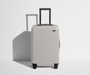 Front product view of The Bigger Carry-On suitcase in Cloud Gray with raised handle