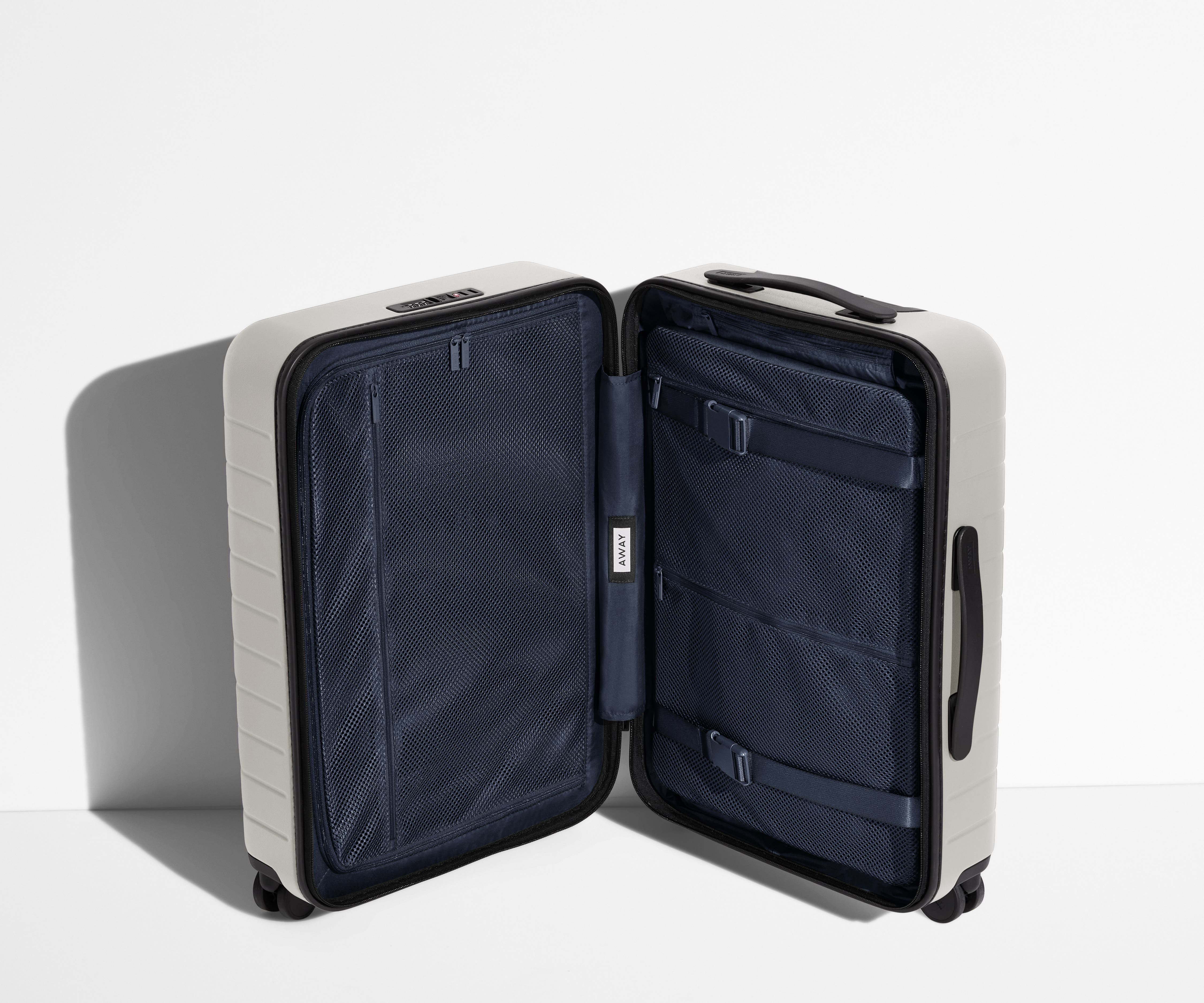 The Bigger Carry-On suitcase in Cloud Gray shown open in an upright position to show interior organization and compression system