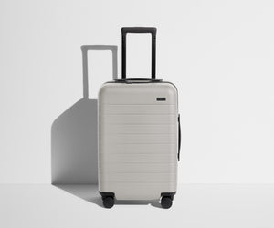Front product view of The Carry-On suitcase in Cloud Gray with raised handle