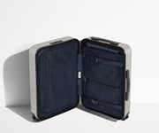 The Carry-On suitcase in Cloud Gray shown open in an upright position to show interior organization and compression system