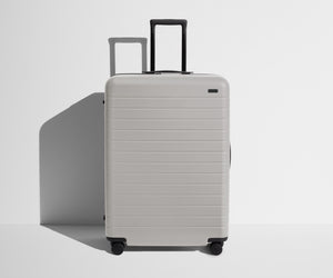 Front product view of The Large suitcase in Cloud Gray with raised handle