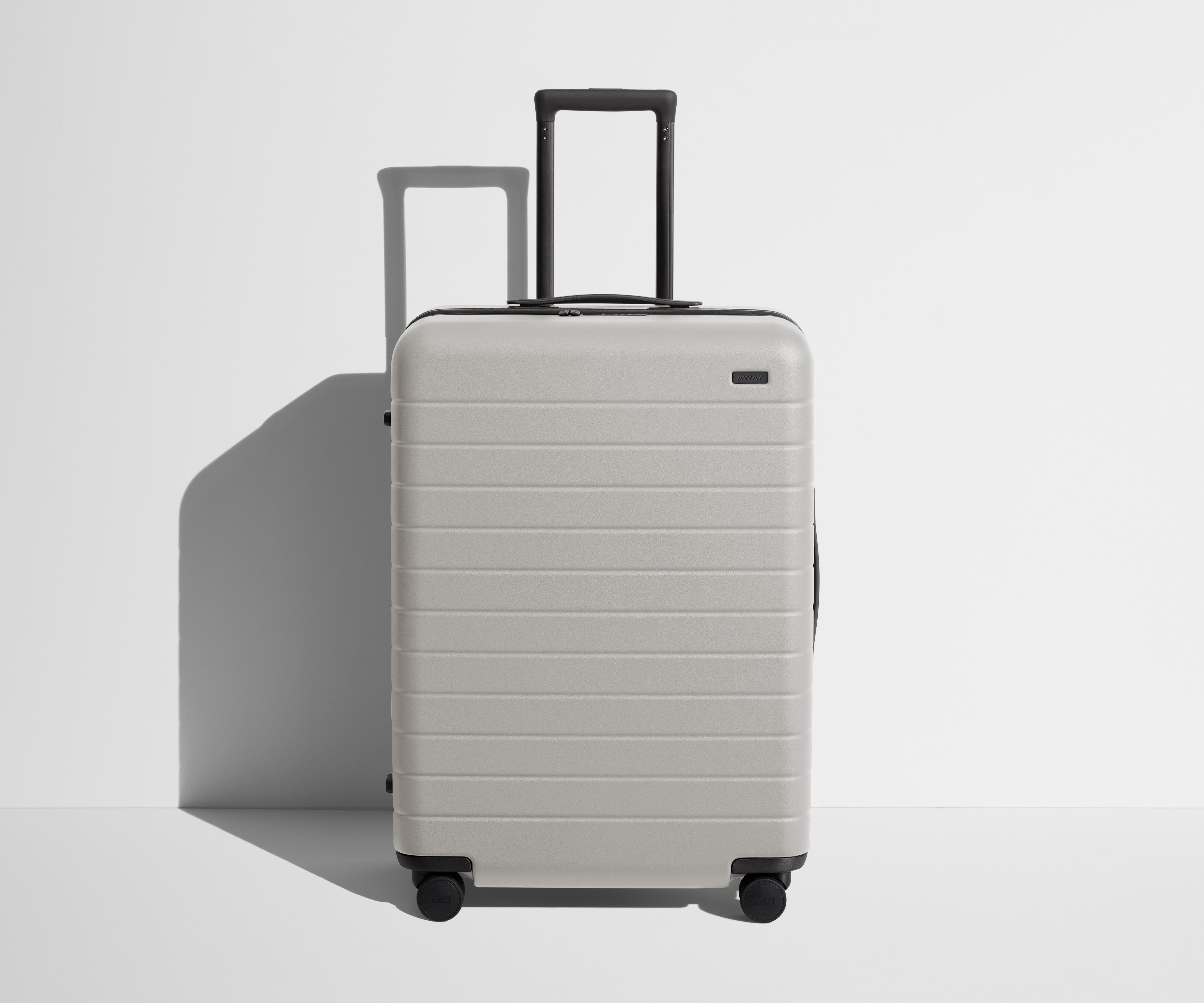 Front product view of The Medium suitcase in Cloud Gray with raised handle