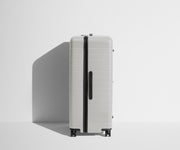 Side product view of The Trunk suitcase in Cloud Gray to show the slimmer top lid and deeper main compartment for easy access and packing