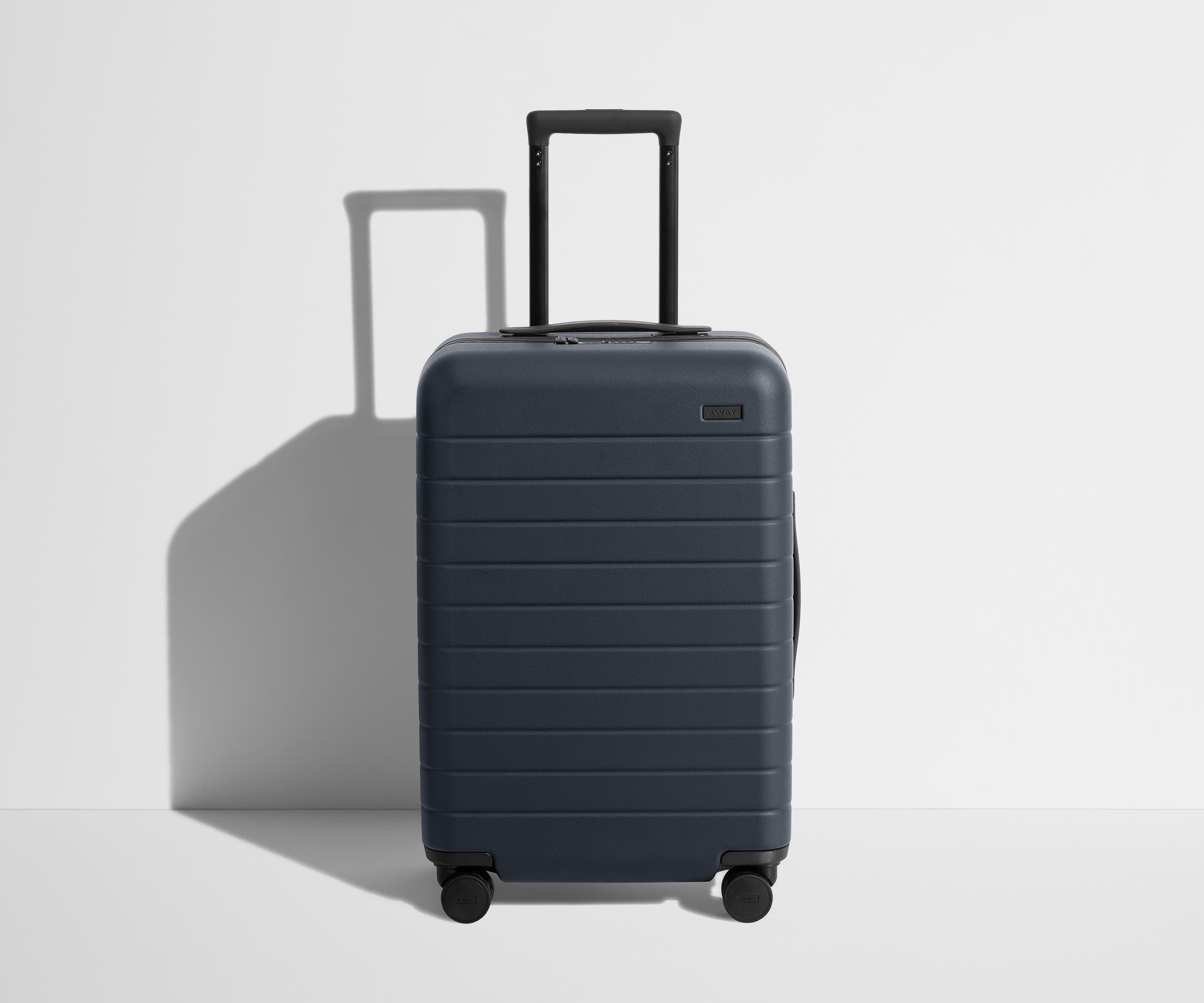 Front product view of The Bigger Carry-On Flex suitcase in Navy Blue with raised handle
