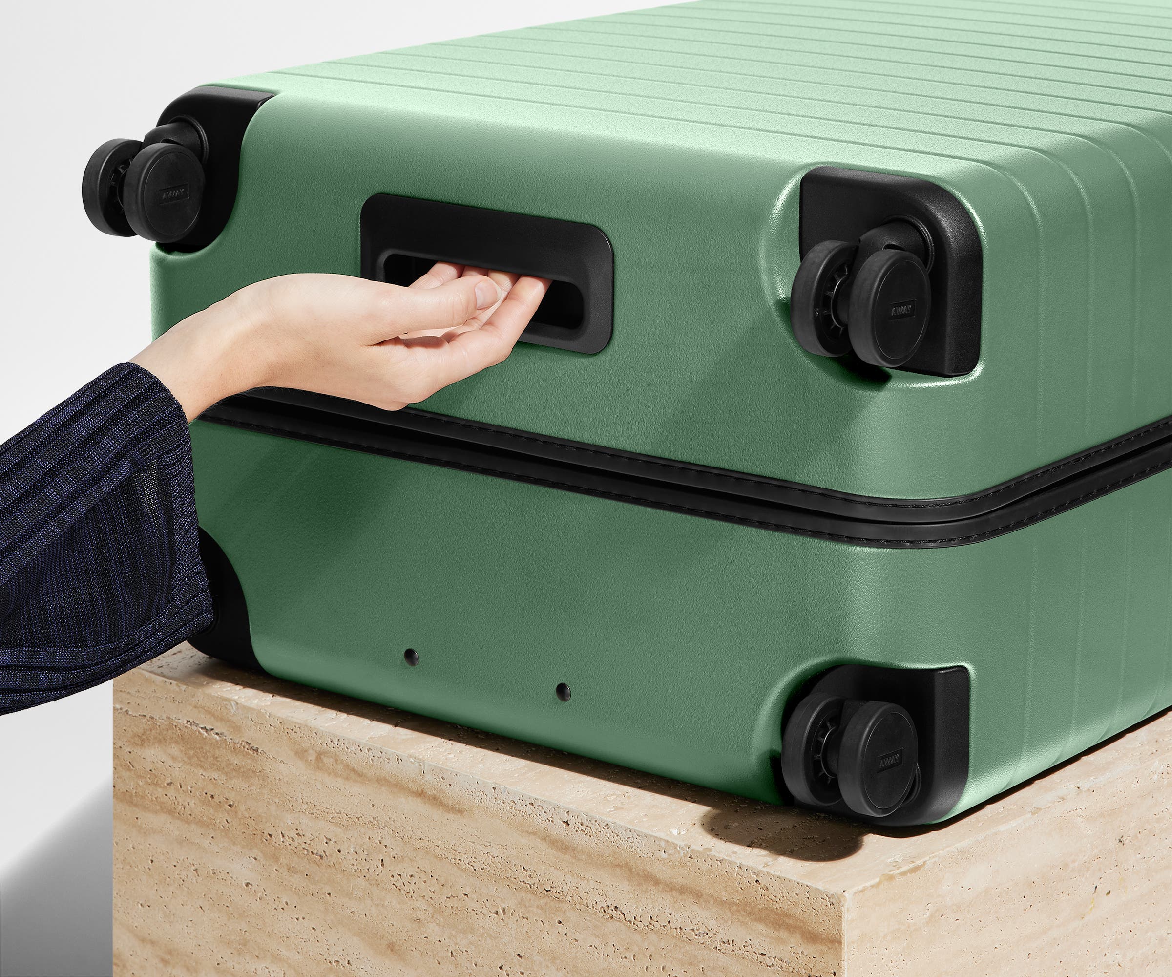The Medium suitcase in Sea Green shown from below highlighting the underside grab handle