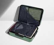 The Medium suitcase in Sea Green shown open on its side and packed with Away's packing organizers to show capacity and the interior compression system, designed to help you pack more in