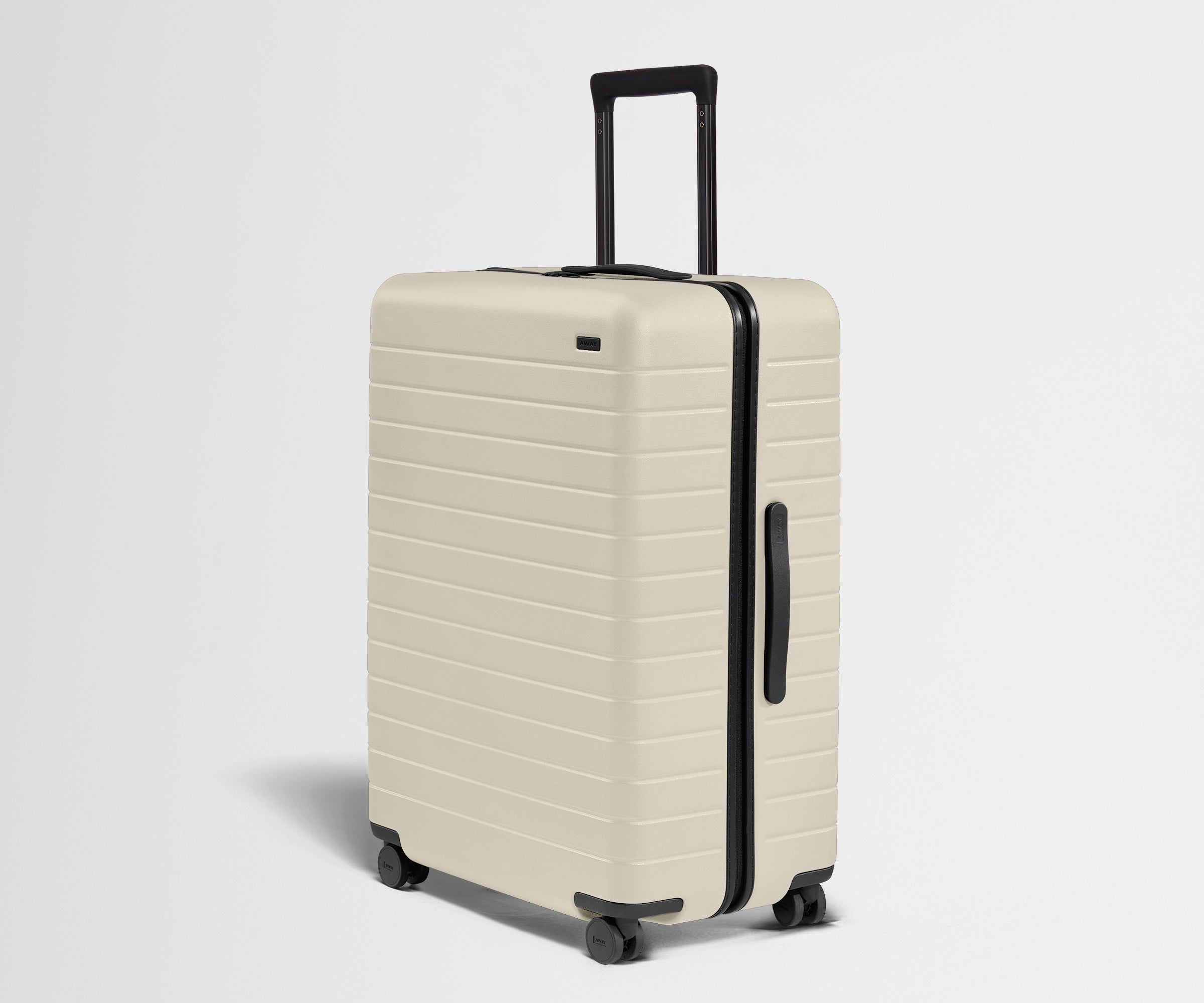 White suitcase with black handle and wheels on a light gray background